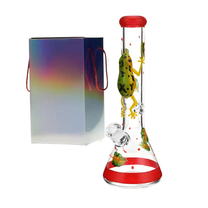 Glass smoking bong with frog design and red accents, accompanied by a colourful box.