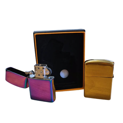 Two flip-top metal lighters, one chrome and one gold, with a black box on a white background.