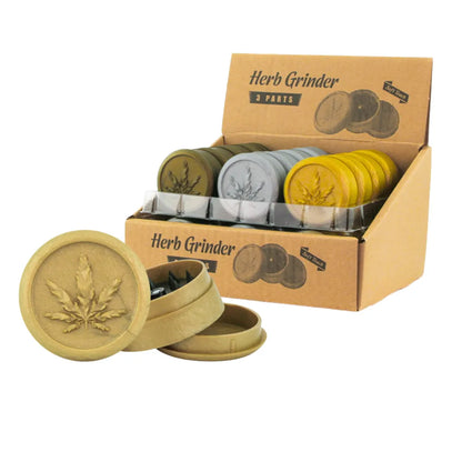Soft touch plastic herb grinders in gold, silver and yellow with cannabis leaf design