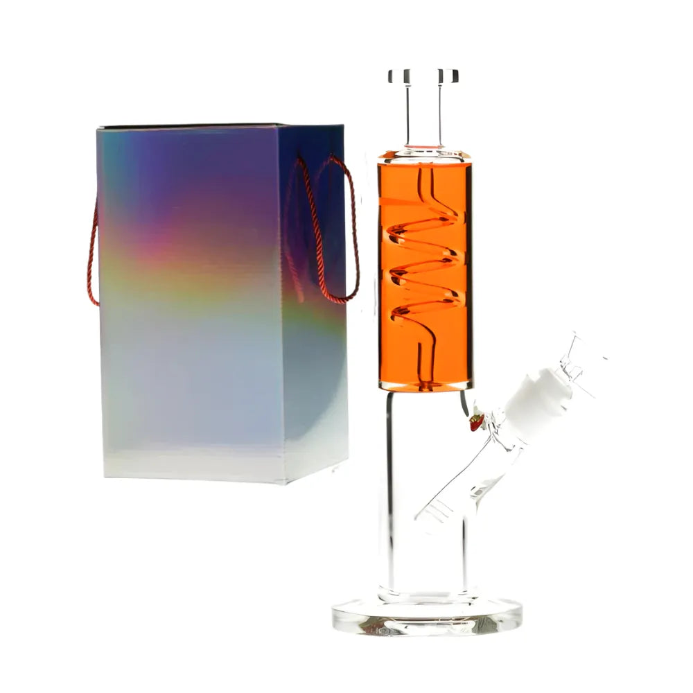 Glass smoking device with orange chamber and clear base, next to a colourful box on a white background