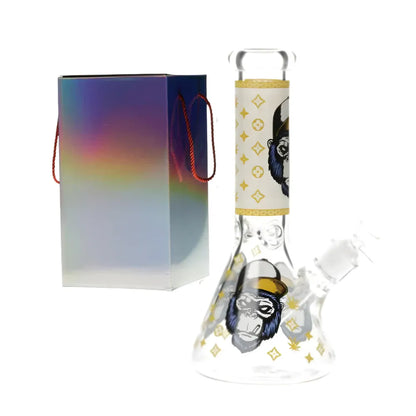 Glass glow in the dark bong with a gorilla design with yellow accents with colourful packaging on a white background.