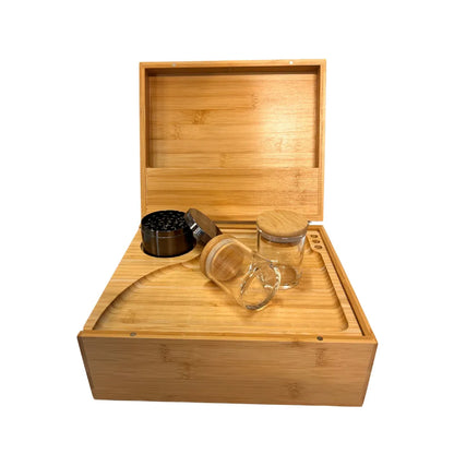 Wooden box with glass jars and a grinder on a white background
