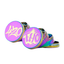 Two colourful Magic Leaf metal grinders with "420" and "THC" designs on a white background