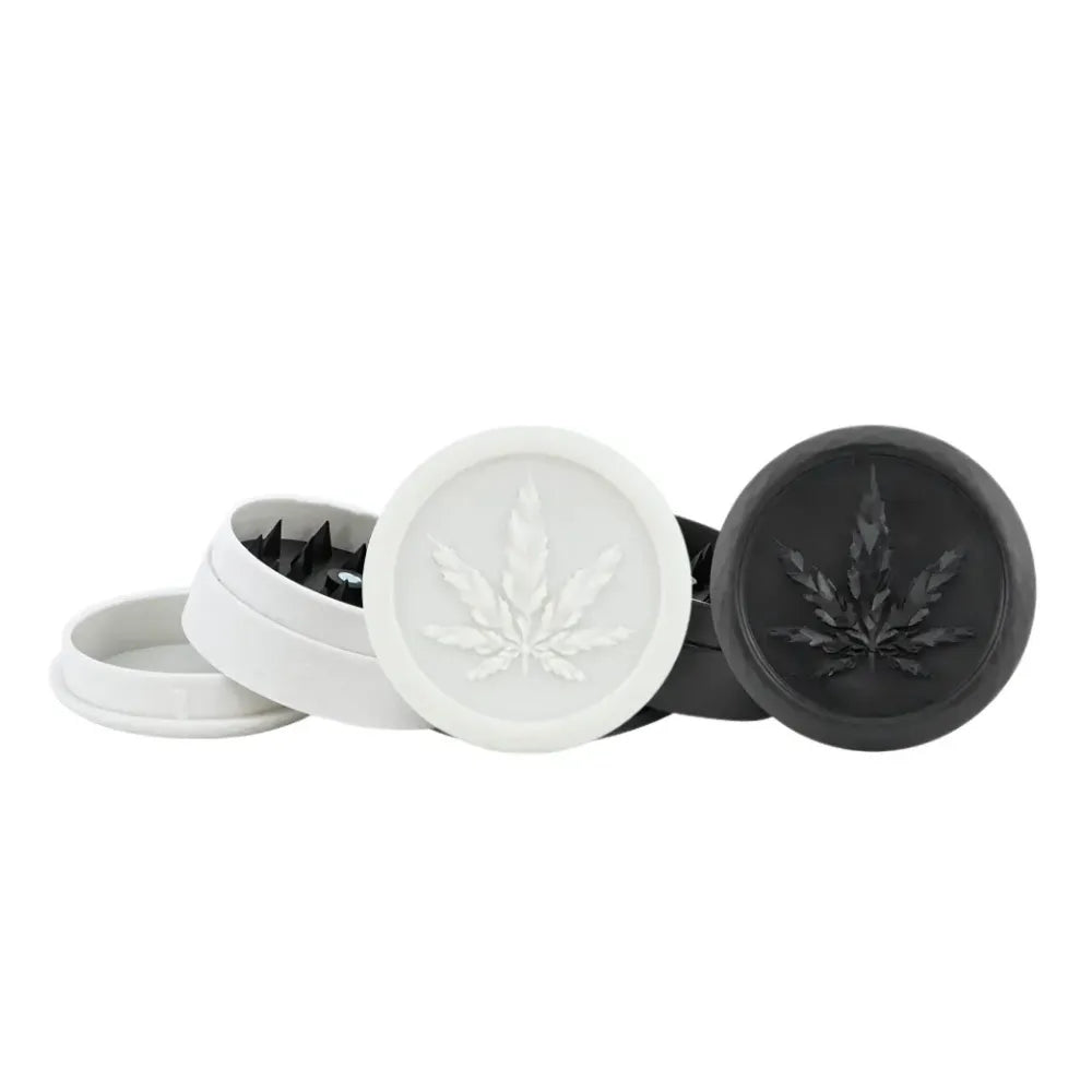 Two black and white Magic Leaf plastic soft touch grinders on a white background