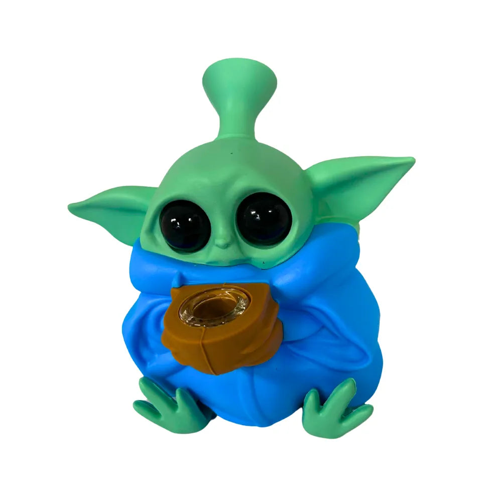 Toy figure of a green and blue creature with large black eyes on a white background